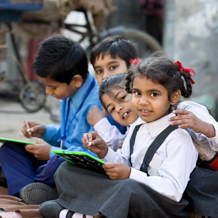 Little schoolboys and schoolgirls in uniform writing on slate